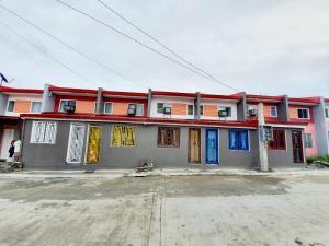 ein Gebäude mit bunten Fenstern und Türen auf einer Straße in der Unterkunft Calapan City Fully Furnished House Transient near XentroMall L39 in Calapan