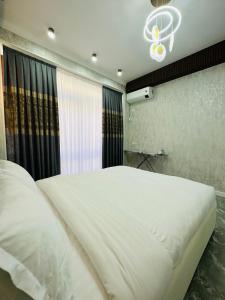 um quarto com uma grande cama branca e uma janela em KERUEN SARAY APARTMENTS 20/2 em Türkistan