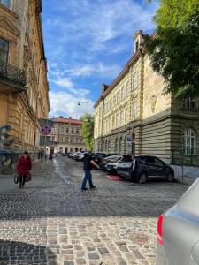 een persoon die door een geplaveide straat met gebouwen loopt bij Vintage apartment in Lviv