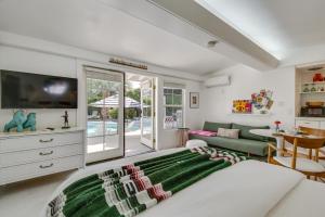 een woonkamer met een groot bed en een bank bij Palm Desert Casita with Pool 5 Blocks to El Paseo in Palm Desert