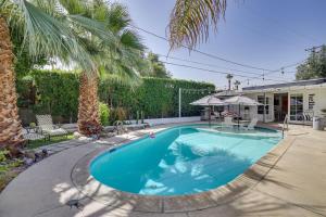 een zwembad in een tuin met een palmboom bij Palm Desert Casita with Pool 5 Blocks to El Paseo in Palm Desert
