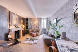 a living room with a couch and a fireplace at Le Florida Auberge contemporaine in Castéra-Verduzan