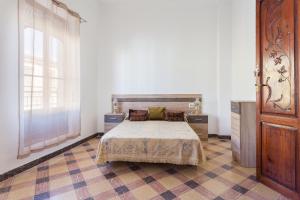een slaapkamer met een bed en een groot raam bij La Matea in Llaurí