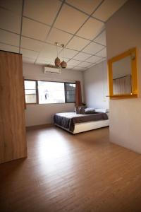 una grande camera da letto con un letto e un pavimento in legno di Holiday Phangan - Hostel & Bar a Thong Sala