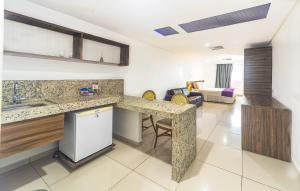 a kitchen with a counter and a living room at Nobile Suítes Tambaú in João Pessoa