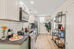 a kitchen with white cabinets and a plate of fruit on the counter at 1 BR Passyunk Ave Stunner- Perfect Location in Philadelphia
