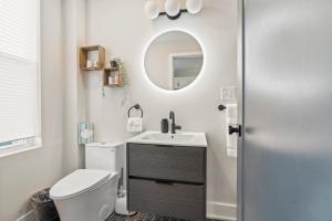 a bathroom with a toilet and a sink and a mirror at 1 BR Passyunk Ave Stunner- Perfect Location in Philadelphia +10 photos