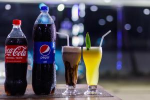 due bottiglie di soda e una bevanda sul tavolo di Pearl Island Inn a Jaffna