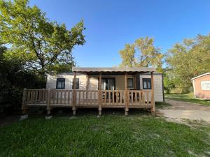 a tiny house with a porch and a deck at Domaine Les Acacias in La Ville-aux-Dames