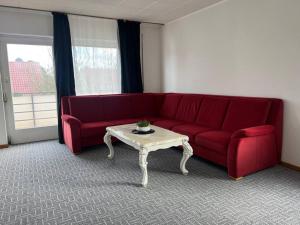 赫爾福德的住宿－Wohnung in Herford，客厅配有红色沙发和茶几