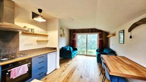 a kitchen with blue cabinets and a wooden table at Eagle's Nest Connemara and Mayo in Westport