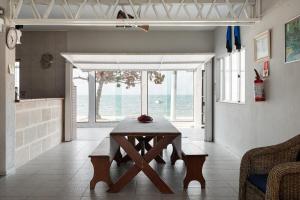 einen Tisch im Wohnzimmer mit Meerblick in der Unterkunft Armação da Piedade Casa Pé na Areia Frente Mar Gov Celso Ramos in Governador Celso Ramos