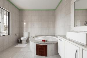 ein weißes Badezimmer mit Badewanne und Toilette in der Unterkunft Armação da Piedade Casa Pé na Areia Frente Mar Gov Celso Ramos in Governador Celso Ramos + 67 Fotos