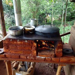 a stove with pots and pans on top of it at Hospedaje jabuticaba in El Soberbio