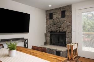 sala de estar con chimenea de piedra y mesa de madera en Nor Ski Haus Estate en Government Camp