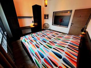 a bed with a colorful comforter in a bedroom at Chambre dans une maison d'hote in Liège