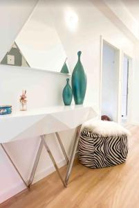 ein weißer Tisch mit Vasen darüber in einem Raum in der Unterkunft Home Sweet Home - Design & Zen in Luxemburg (Stadt)