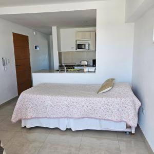 a bedroom with a bed with a pink blanket on it at BELGRANOPtoMadryn in Puerto Madryn
