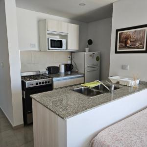 a kitchen with a sink and a stove top oven at BELGRANOPtoMadryn in Puerto Madryn