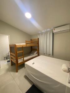 a bedroom with two beds and a bunk bed at Bangalô Dunas in Barreirinhas