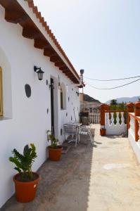 un patio de una casa blanca con mesa y sillas en Casa Sendero de Taidia, en San Bartolomé