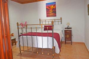 a bedroom with a bed with a red and white blanket at Casa Sendero de Taidia in San Bartolomé