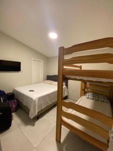 a bedroom with two bunk beds and a flat screen tv at Bangalô Dunas in Barreirinhas