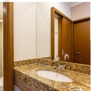 a bathroom with a sink and a mirror at Ondas Praia Resort - MC in Porto Seguro