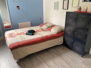 a bedroom with a bed and a dresser with a stuffed animal on it at Sweet cosy home spacieux 2 rooms in Montigny-le-Bretonneux