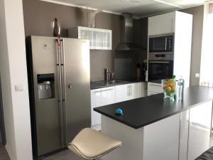 a kitchen with a refrigerator and a black counter top at Sweet cosy home spacieux 2 rooms in Montigny-le-Bretonneux