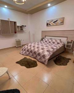 een slaapkamer met een groot bed met tapijten op de vloer bij BOUGIE LOFT in Bejaïa