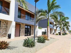 a building with palm trees in front of it at Tuscany Residence Aruba in Palm-Eagle Beach