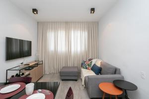 uma sala de estar com um sofá e uma televisão em Moderno apartamento, 2 quartos em Belo Horizonte