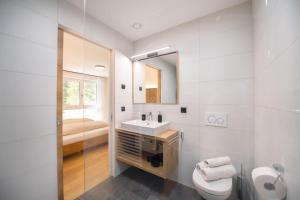 een witte badkamer met een wastafel en een toilet bij Living Miramor in Racines