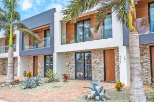 a building with palm trees in front of it at Tuscany Residence Aruba in Palm-Eagle Beach