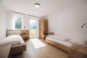 1 dormitorio con 2 camas y ventana en Living Miramor, en Racines