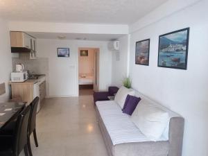 a living room with a white couch and a kitchen at Apartment Feral in Neum