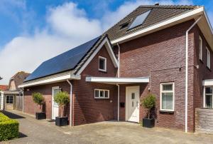 a red brick house with solar panels on it at Aanloop 22 in Domburg