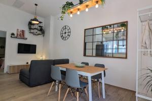 a dining room with a table and chairs and a couch at Pepper House - cozy apartment in Conversano
