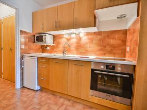 Kuchnia z drewnianymi szafkami, zlewem i kuchenką mikrofalową w obiekcie Studio central avec balcon sud, proche téléphériques, parking couvert inclus, pour 4 pers. - FR-1-684-19 w mieście Morzine