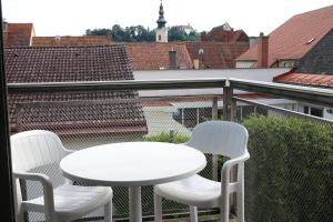 einen weißen Tisch und zwei Stühle auf dem Balkon in der Unterkunft Provianthaus in Bad Radkersburg