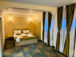a bedroom with a bed and some windows at Hotel La Ane in Babadau