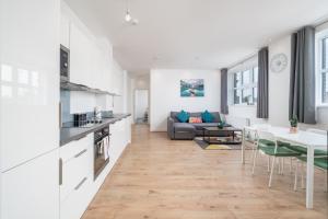 uma cozinha e sala de estar com um sofá e uma mesa em Luxury 2 Bedroom Apartment Free Parking, Netflix, Sleeps 6 em Watford