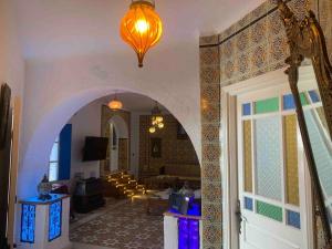 een woonkamer met een boog en een woonkamer met een woonkamer bij Charming house in Arabesque style in Hammamet Nord