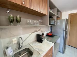 uma cozinha com um lavatório e um frigorífico em ILE DE PIPA Oásis - By Almare Flats em Pipa