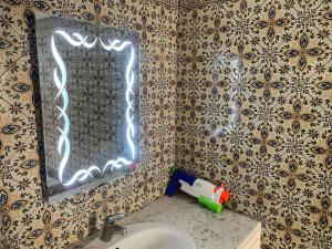 een badkamer met een wastafel en een spiegel bij Charming house in Arabesque style in Hammamet Nord