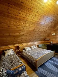 two beds in a room with a wooden wall at Holiday home Imanta in Rīga