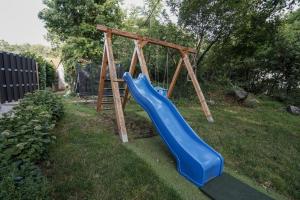a playground with a blue slide in a yard at Apartman Marija Imotski in Imotski
