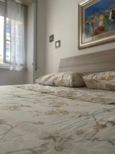 Un dormitorio con una cama con almohadas y una pintura en Distretto 14 en Roma
