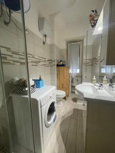 a bathroom with a washing machine and a sink at Distretto 14 in Rome